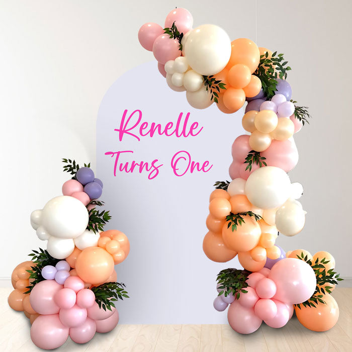 Garden themed balloon garland backdrop against a customised archway board.