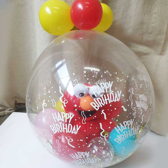 Elmo plush toy in a balloon wrapped as a surprise gift.