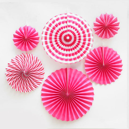Hot Pink paper fans mixed with polkadots and swirls and stripes provides high contrasts of colours.