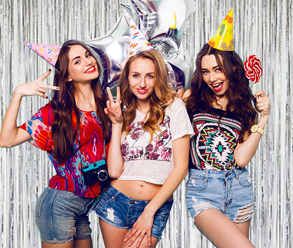 Girls celebrating with these silver foil streamer backdrop.