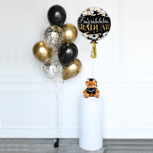 Lovely graduation bear holding on to a bubble balloon and a chrome gold and confetti balloon bouquet for the new graduate.