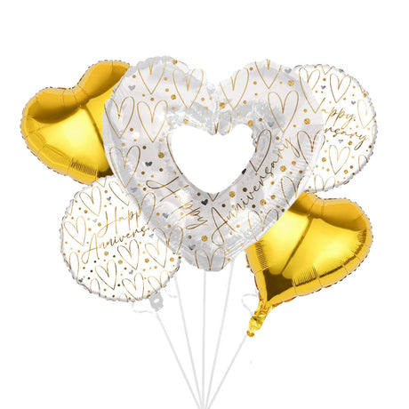 A set of metallic foil balloons shaped in hearts, including two gold heart balloons and two white heart balloons with gold heart patterns and 'Happy Anniversary' script, tied together with white strings on a white background.