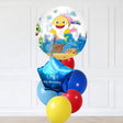 Colorful balloons with a 'Baby Shark' design against a white wall.