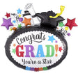 A celebratory graduation foil balloon set on a plain white background. The main balloon is black with a white center panel that reads “Congrats GRAD! You’re a Star” in colorful lettering, topped with a black graduation cap, rolled diploma, yellow diploma pen, and scattered multicolor stars.