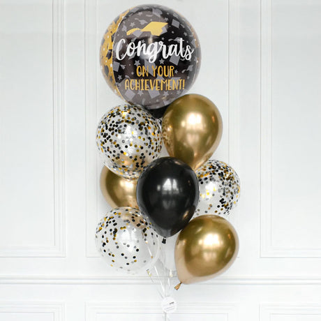 Graduation-themed balloon bouquet with 'Congrats on your achievement!' message against a white background