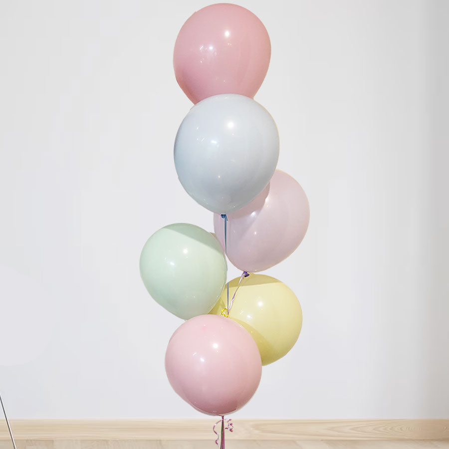 Soft and pastel coloured balloons in a bouquet display.