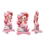 Three cartoon mermaid figurines with pink hair and tails on a white background