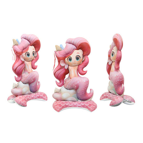 Three cartoon mermaid figurines with pink hair and tails on a white background