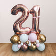 Lovely Rose Gold Double Number Balloon Cluster Stand for the 21st Birthday milestone party, in shiny chrome gold and rose gold colours and enhanced with pink accent.
