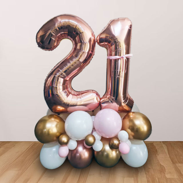 Lovely Rose Gold Double Number Balloon Cluster Stand for the 21st Birthday milestone party, in shiny chrome gold and rose gold colours and enhanced with pink accent.
