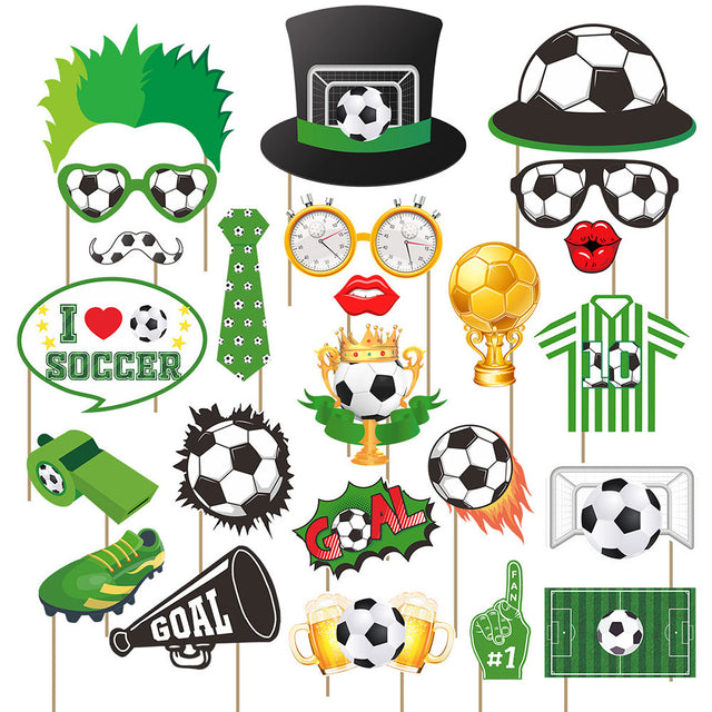 A set of soccer-themed photo booth props on wooden sticks, including a top hat with a soccer ball, soccer glasses, a mustache, a green tie, clock-shaped glasses, red lips, a soccer ball trophy, a striped jersey, a megaphone, a whistle, a football, a goal graphic, beer mugs, and a number 1 foam finger.