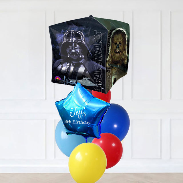 Star Wars-themed balloon set with personalized balloon in front of a white paneled wall.