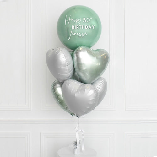 Mint green orbz balloon matching with chrome heart balloons to form a balloon bouquet for the birthday star.Customised Mint Orbz Balloon with Hearts Foil Bouquet