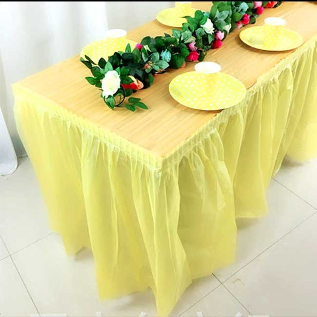Dining table set up with yellow themed table cover and skrting
